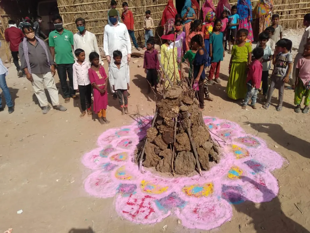 Holika Dahan — the settlement gathers around the bonfire for Holi.