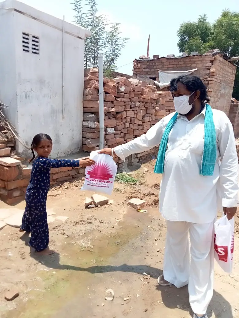 A child receives a relief kit at her doorstep.