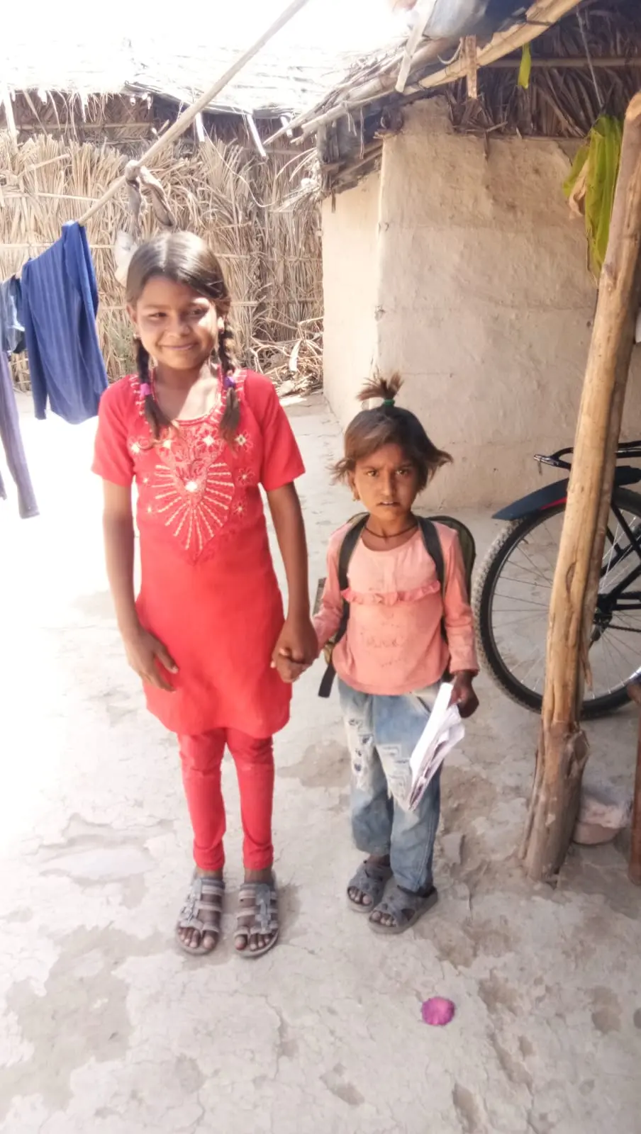 An older sister walks her younger sibling to class.