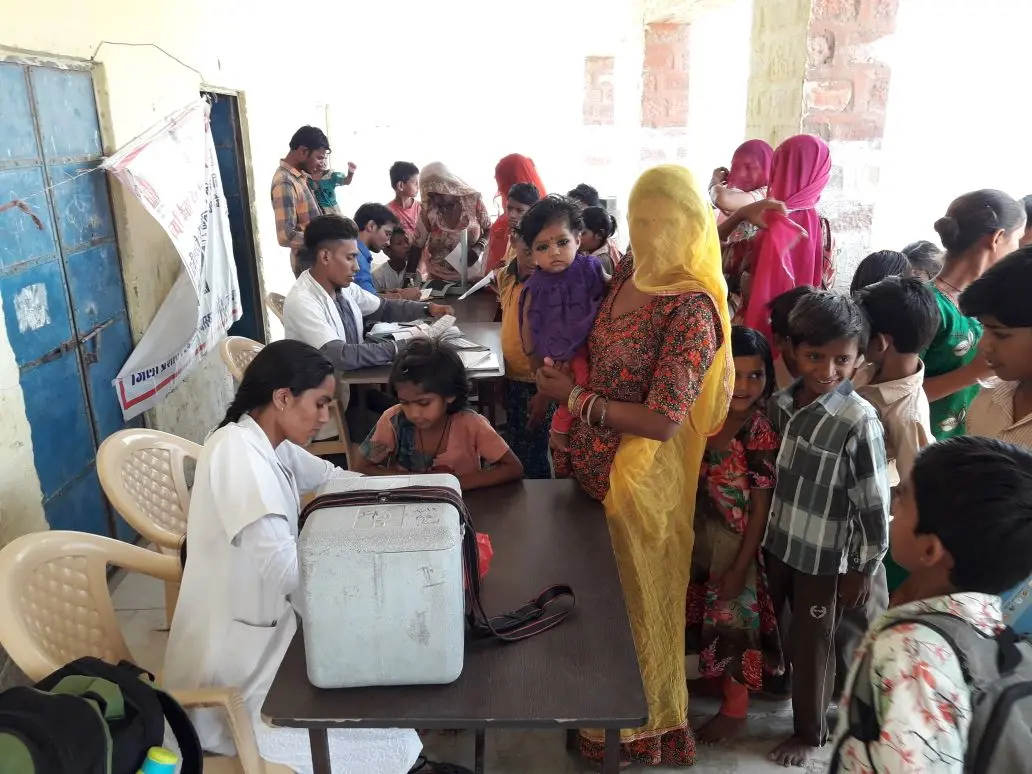 A mobile medical consultation — mothers and children queue to see the visiting health worker.