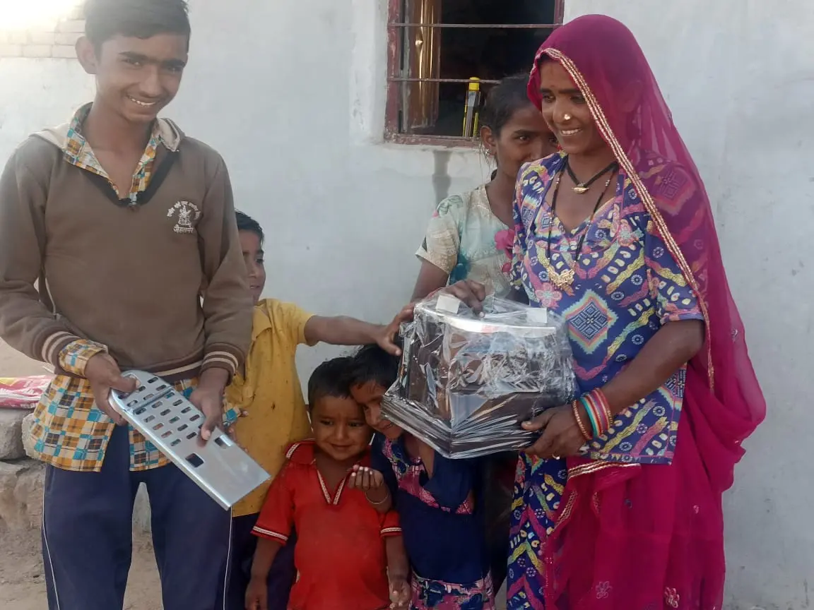 A family receives their stove, children looking on.